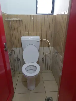 a bathroom with a white toilet in a stall at Tropical Blooms by StayApart in Kutta