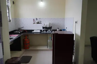 a kitchen with a counter and a refrigerator at Golden Bells in Vānivilāsa Puram
