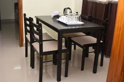a black table and chairs with a phone on it at Golden Bells in Vānivilāsa Puram