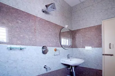 a bathroom with a sink and a mirror at Nagadeep Residency in Mysore