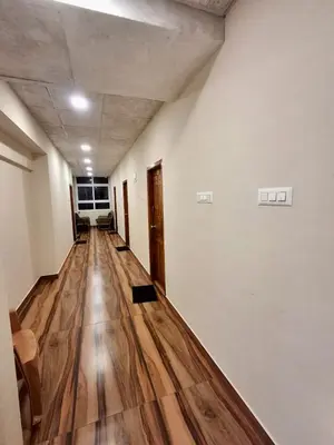 an empty hallway with wooden floors in a building at Nagadeep Residency in Mysore