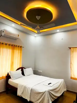 a bedroom with a large bed with a ceiling at Nagadeep Residency in Mysore