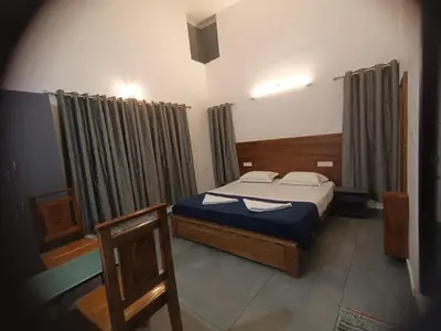 a bedroom with a bed in a room with curtains at Aditi HOMESTAY in Kalpetta