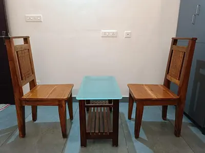 two chairs and a table with a blue table at Aditi HOMESTAY in Kalpetta