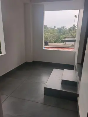an empty room with a window and a bench at Aditi HOMESTAY in Kalpetta