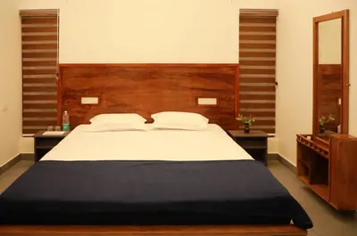 a bedroom with a large bed with a wooden headboard at Aditi HOMESTAY in Kalpetta