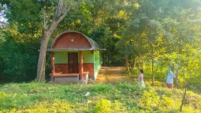 a small building with a small child standing next to it at Sradha Farm Stay - Kollengode in Kollengode