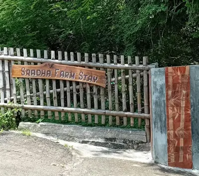 a wooden fence with a sign that reads backyard farmstay at Sradha Farm Stay - Kollengode in Kollengode