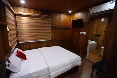 a bedroom with a white bed and a bathroom at Karingens Resort in Malayāttūr