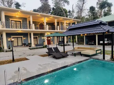 a house with a swimming pool in front of a house at Villa Forever Coorg in Madikeri