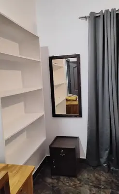 a room with white shelves and a mirror at Mitra retreats in Mānantoddy