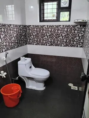 a bathroom with a white toilet in a room at Mitra retreats in Mānantoddy