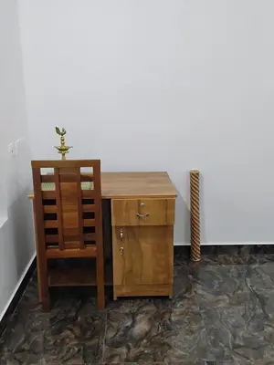 a wooden desk and a cabinet with a plant on top at Mitra retreats in Mānantoddy