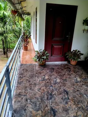 a front porch with a red door and potted plants at Mitra retreats in Mānantoddy
