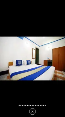 a bedroom with a large bed with blue pillows at Raahath Inn Munnar in Munnar