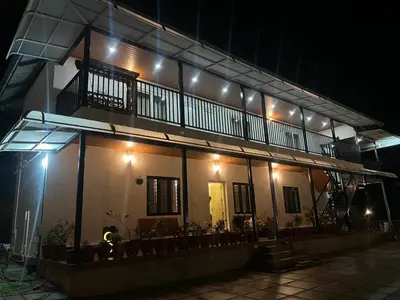 a building with lights on top of it at night at Orange Valley Farm Resort in Munnar