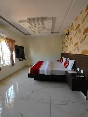 a bedroom with a large bed and a tv at Dkgardenia24 in Kanakapura