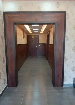 an empty hallway with wooden doors and ailed floor at Dkgardenia24 in Kanakapura