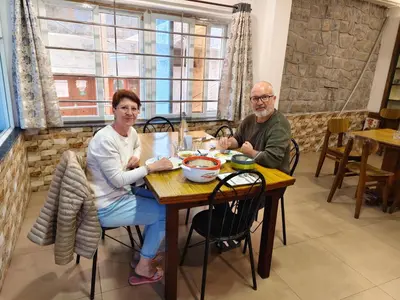 a man and a woman sitting at a table at Hornbill Castle in Vālpārai