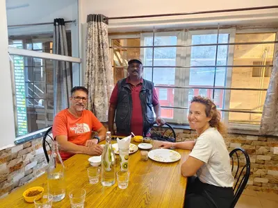 a group of three people sitting around a table at Hornbill Castle in Vālpārai