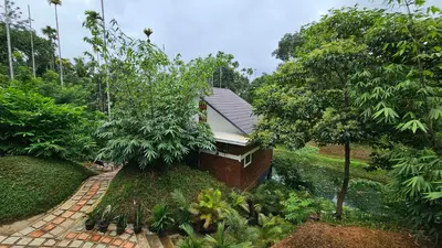 a house in the middle of a garden at Casta Wild Resort in Batheri