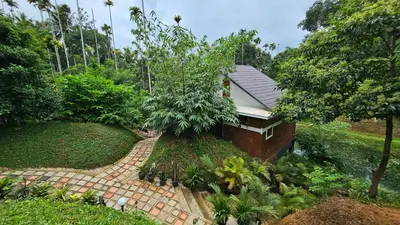a house with a brick walkway in a garden at Casta Wild Resort in Batheri