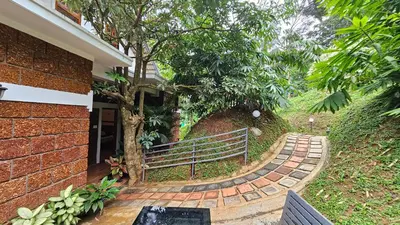 a brick walkway with a bench next to a house at Casta Wild Resort in Batheri