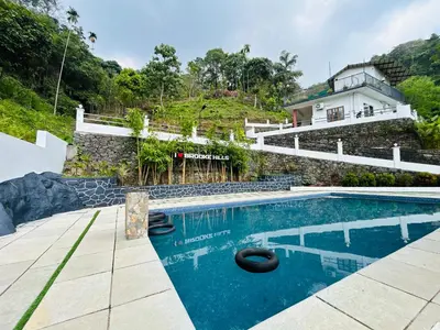 a villa with a swimming pool and a house at Brooke hills falls view in Vallikavungal