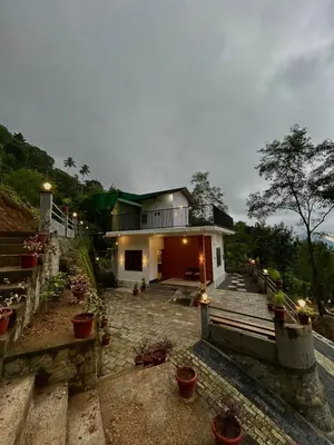 a house with potted plants in front of it at Brooke hills falls view in Vallikavungal