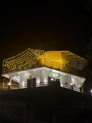 a building with lights on top of it at night at Brooke hills 2 BHK villa falls view in Vallikavungal