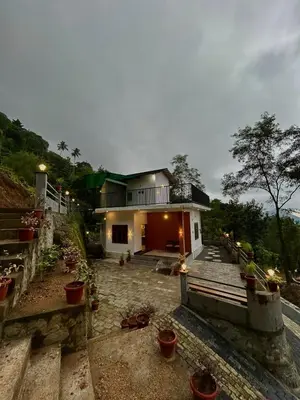 a house with potted plants in front of it at Brooke hills 2 BHK villa falls view in Vallikavungal