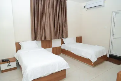 a room with two beds and a window at Hotel BR Grand in Coimbatore