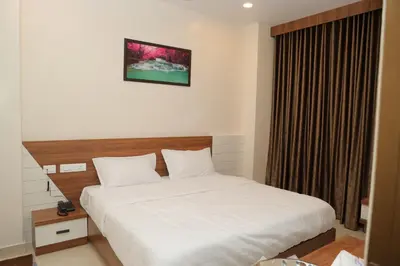 a hotel room with a bed and a window at Hotel BR Grand in Coimbatore
