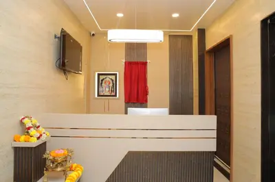 a waiting room with a reception desk and a mirror at Hotel BR Grand in Coimbatore