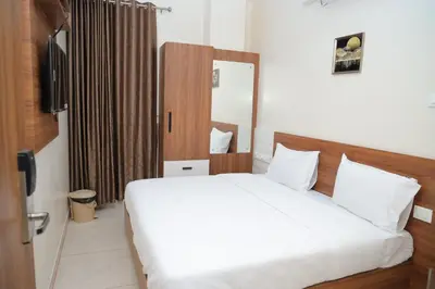 a bedroom with a white bed and a mirror at Hotel BR Grand in Coimbatore