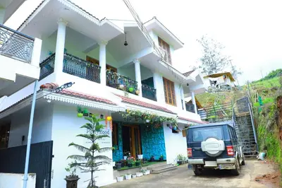 a house with a jeep parked in front of it at Pine Hood Villa in Ooty