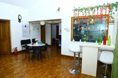 a bar in a room with a table and chairs at Pine Hood Villa in Ooty