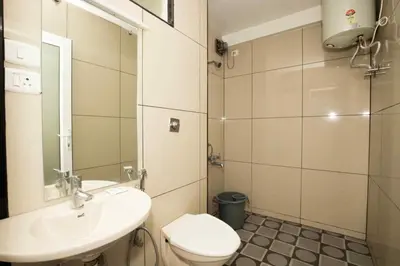 a bathroom with a sink and a toilet and a mirror at Lazo Silver Lake , Ooty in Ooty