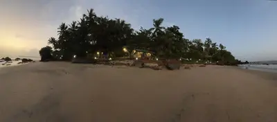 a house on the beach at night at Rocks beach house in Kannur