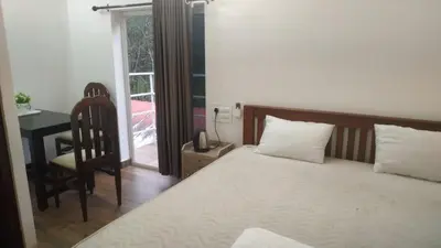 a bedroom with a bed and a desk and a chair at Randukai Farm House in Athirappally