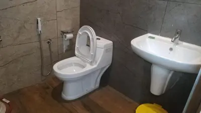 a bathroom with a toilet and a sink at Randukai Farm House in Athirappally