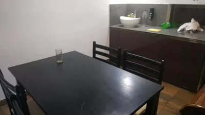 a black table with two chairs and a glass on it at Randukai Farm House in Athirappally