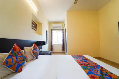 a bedroom with a large white bed with colorful pillows at Via Aarudra s Residency in Coimbatore
