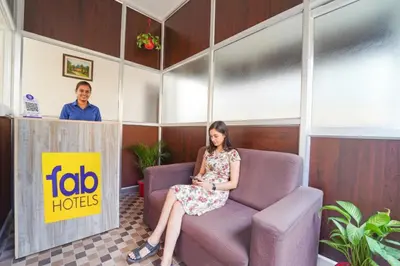 a woman sitting on a chair in a waiting room at Via Aarudra s Residency in Coimbatore