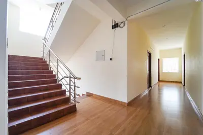 a staircase in a building with a wooden floor at Via Aarudra s Residency in Coimbatore