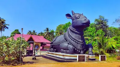a statue of a cow in front of a building at Rustic Retreat in Perumbavoor
