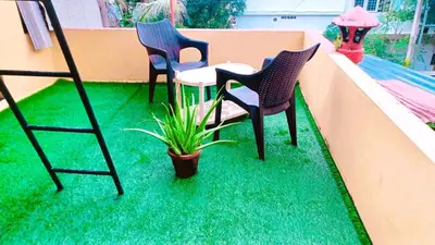 two chairs and a table and a potted plant on a balcony at Rustic Retreat in Perumbavoor