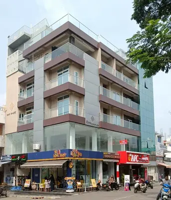 a tall building with people sitting in front of it at Eve Service apartment in Mysore