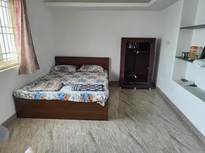 a bedroom with a bed and a dresser in it at MMVK Homestay AC, Spacious & Comfortable Entire Home Just For You in Pollāchi