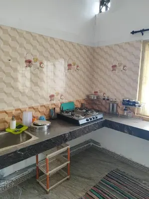 a kitchen with a stove and a counter top at MMVK Homestay AC, Spacious & Comfortable Entire Home Just For You in Pollāchi